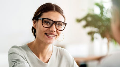 Femme serrant des mains et obtenant sa certification dans un centre de langues Berlitz