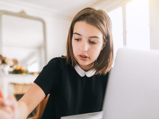 Jeune fille devant son ordinateur pour un cours de langue en ligne