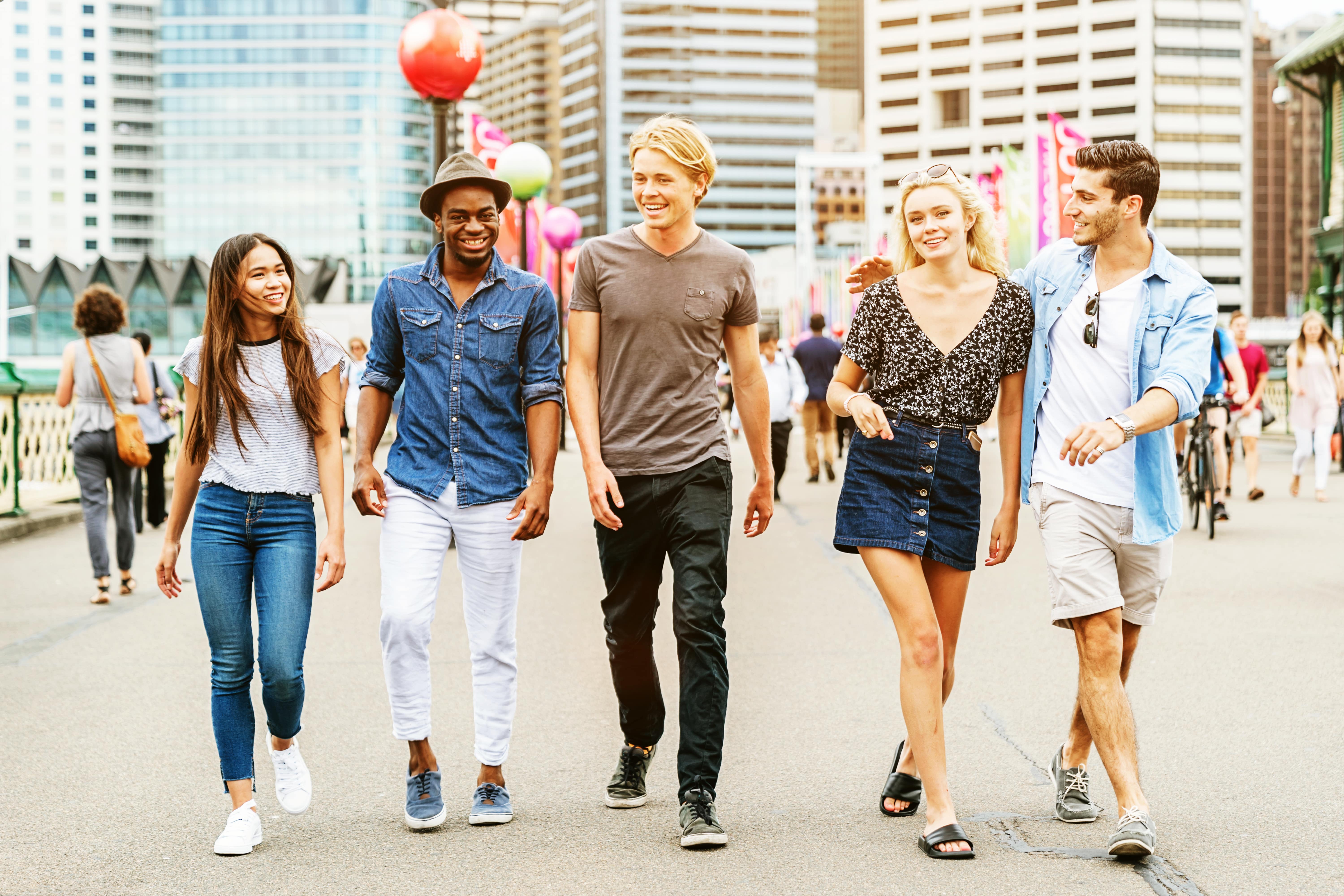 A group of friends walking in a city and talking about their plans for the weekend