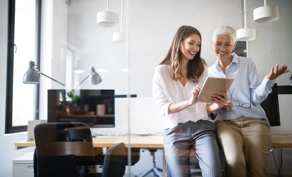 Formatrice montrant un document à son élève et lui souriant lors d'un communication interculturelle formation avec Berlitz France