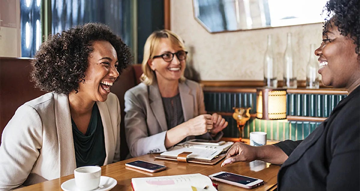 Women at a table in a bar talking about how to compose a good letter for better job opportunities