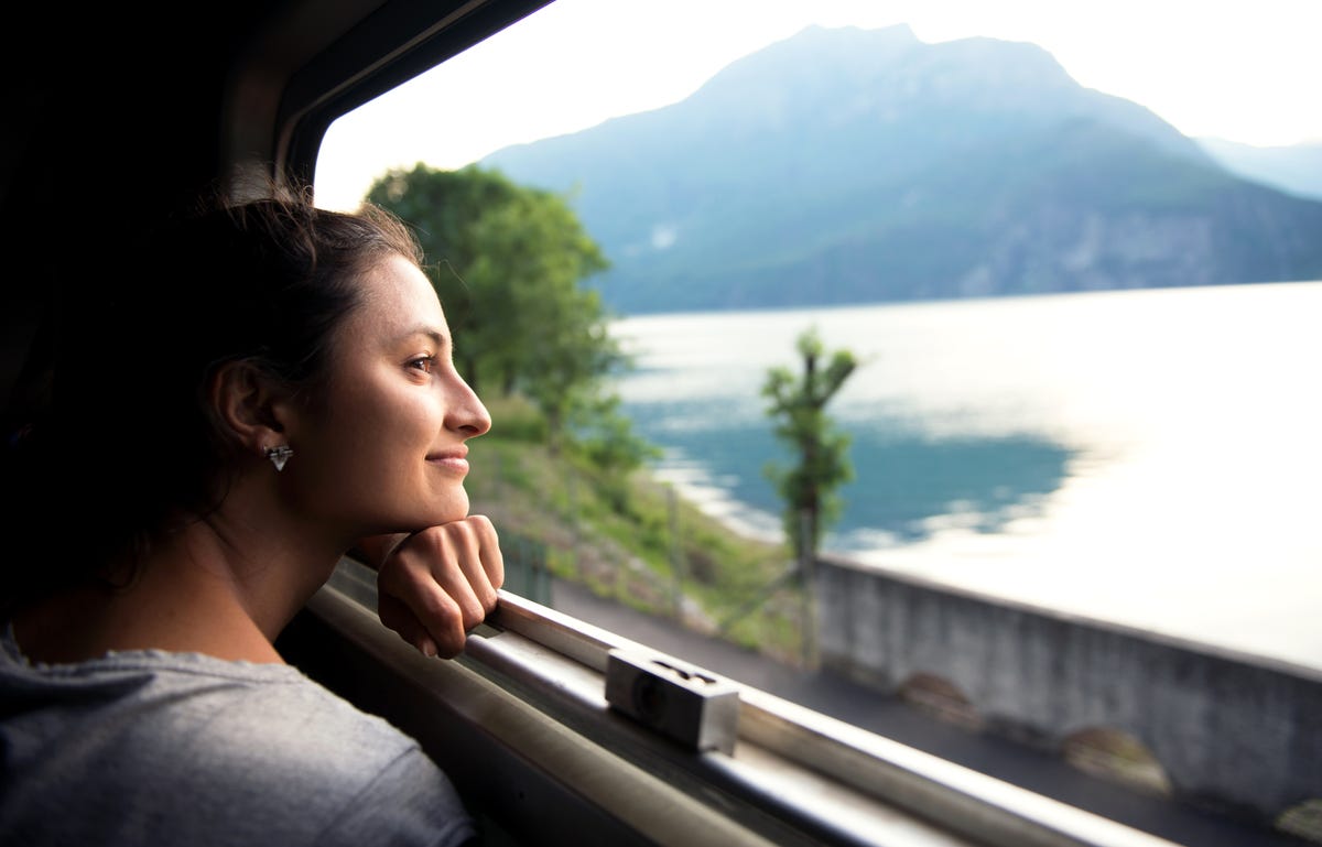Woman looking at the scenery from the train window while traveling abroad to study a language with Berlitz