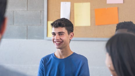 Adolescents assis sur des chaises en cercle et parlant entre eux en cours anglais vacances été