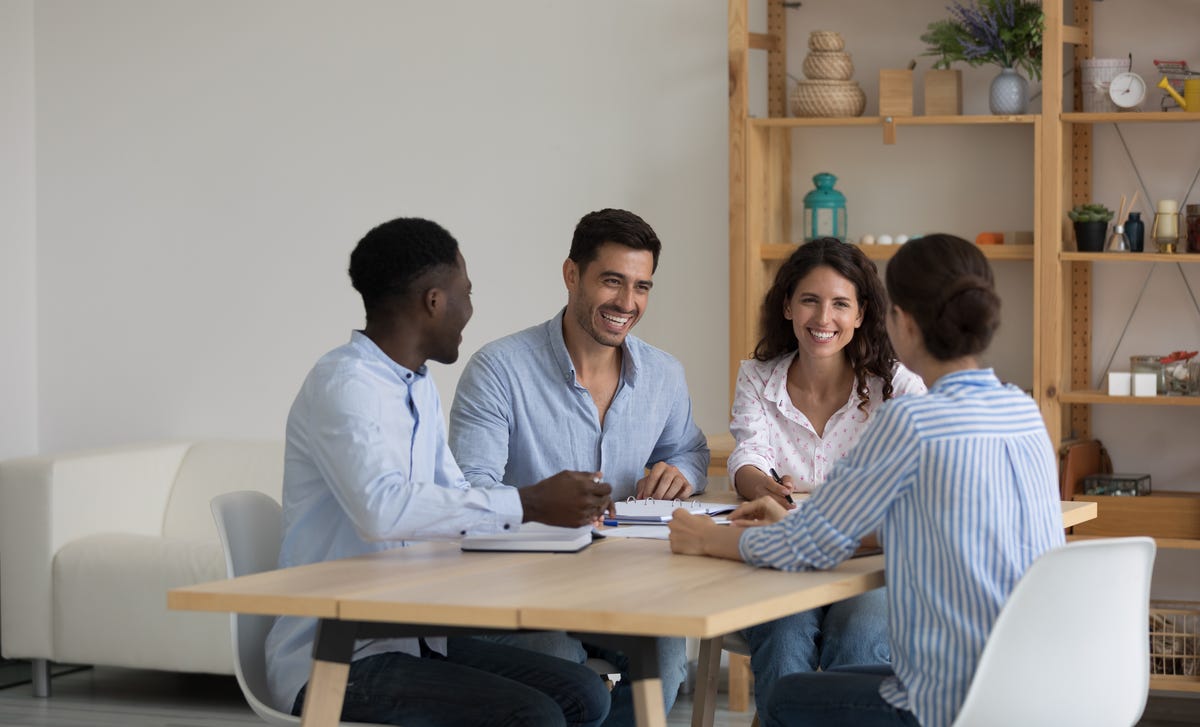 Groupe d'étudiants participant à un cours de langue en face à face et écoutant leur formateur parler dans la langue cible.
