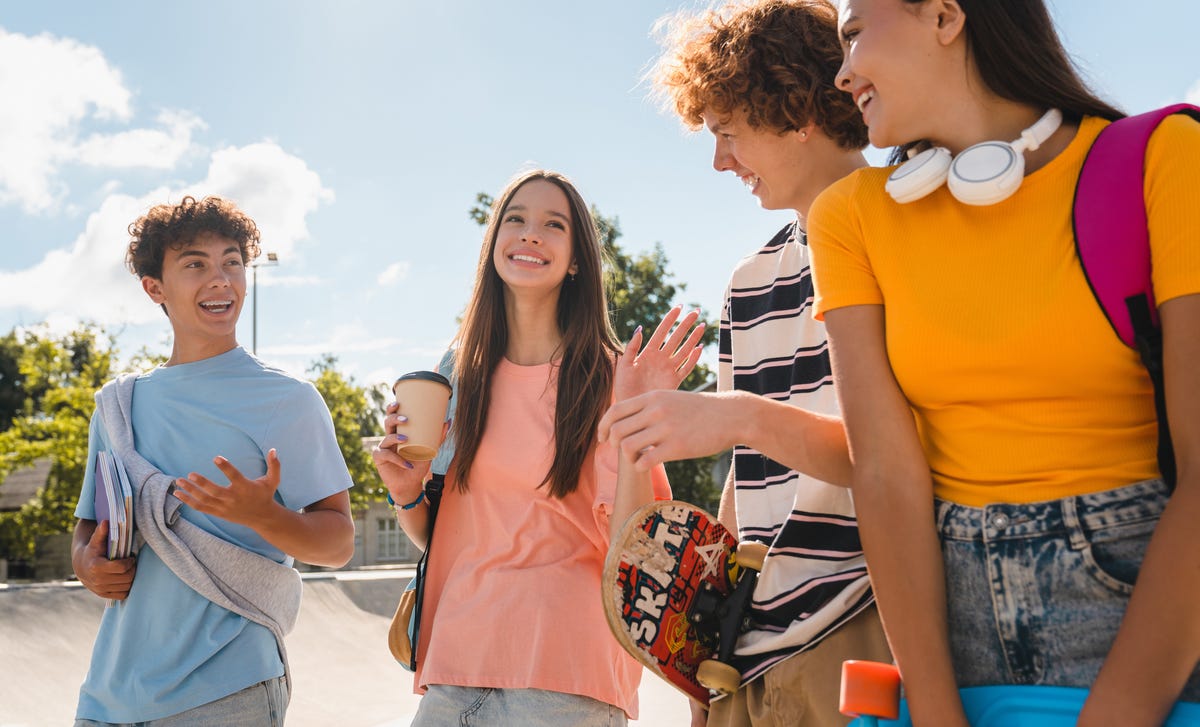 Groupe d'adolescents souriant et discutant entre eux sur le chemin de leur sejour linguistique ado avec Berlitz