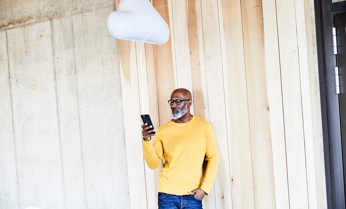 Homme en chemise jaune tenant son téléphone et appelant le Berlitz numéro