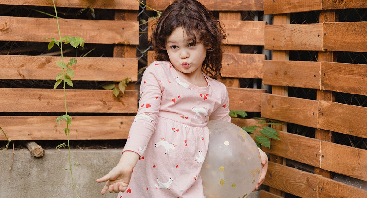 Little girl in a beautiful pink dress with unicorns posing for the camera