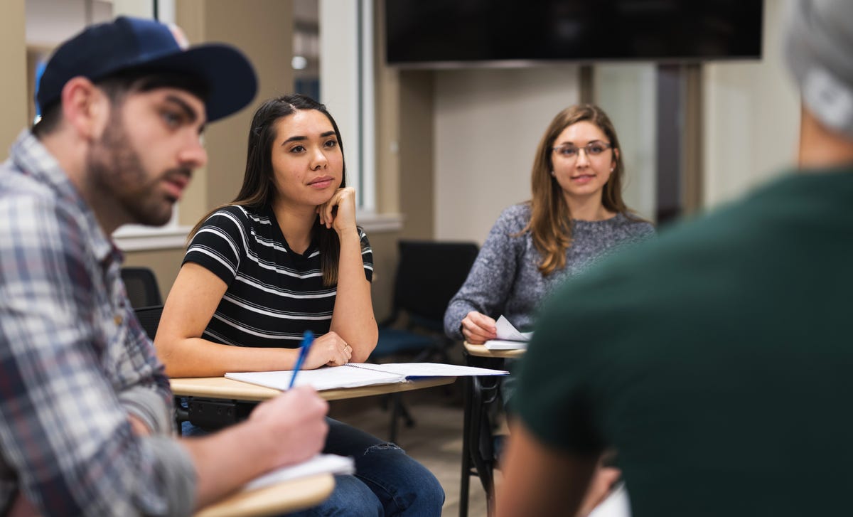 Students sitting at their tables and listening to their instructor during an English lesson with Berlitz Rouen