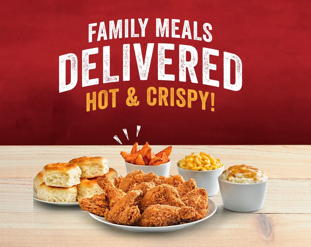 Hot and Crispy Fried Chicken Family Meal surrounded by sides of Mac and Cheese, Mashed Potatoes, Biscuits, and Potato Wedges.