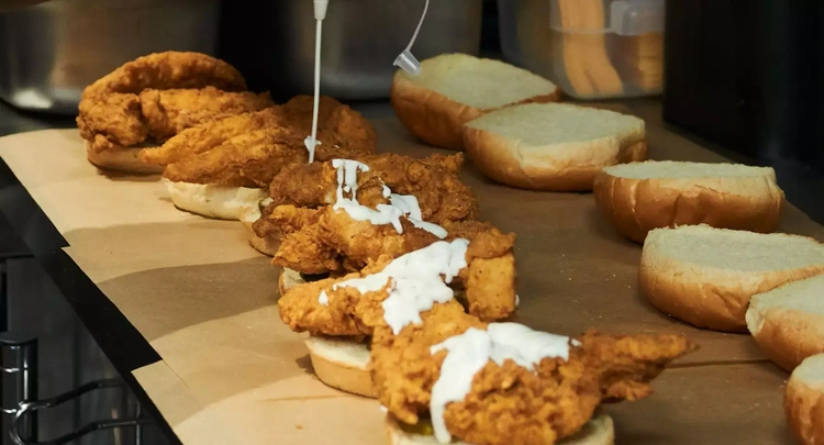 Crispy Chicken Sandwiches being drizzled with sauce.