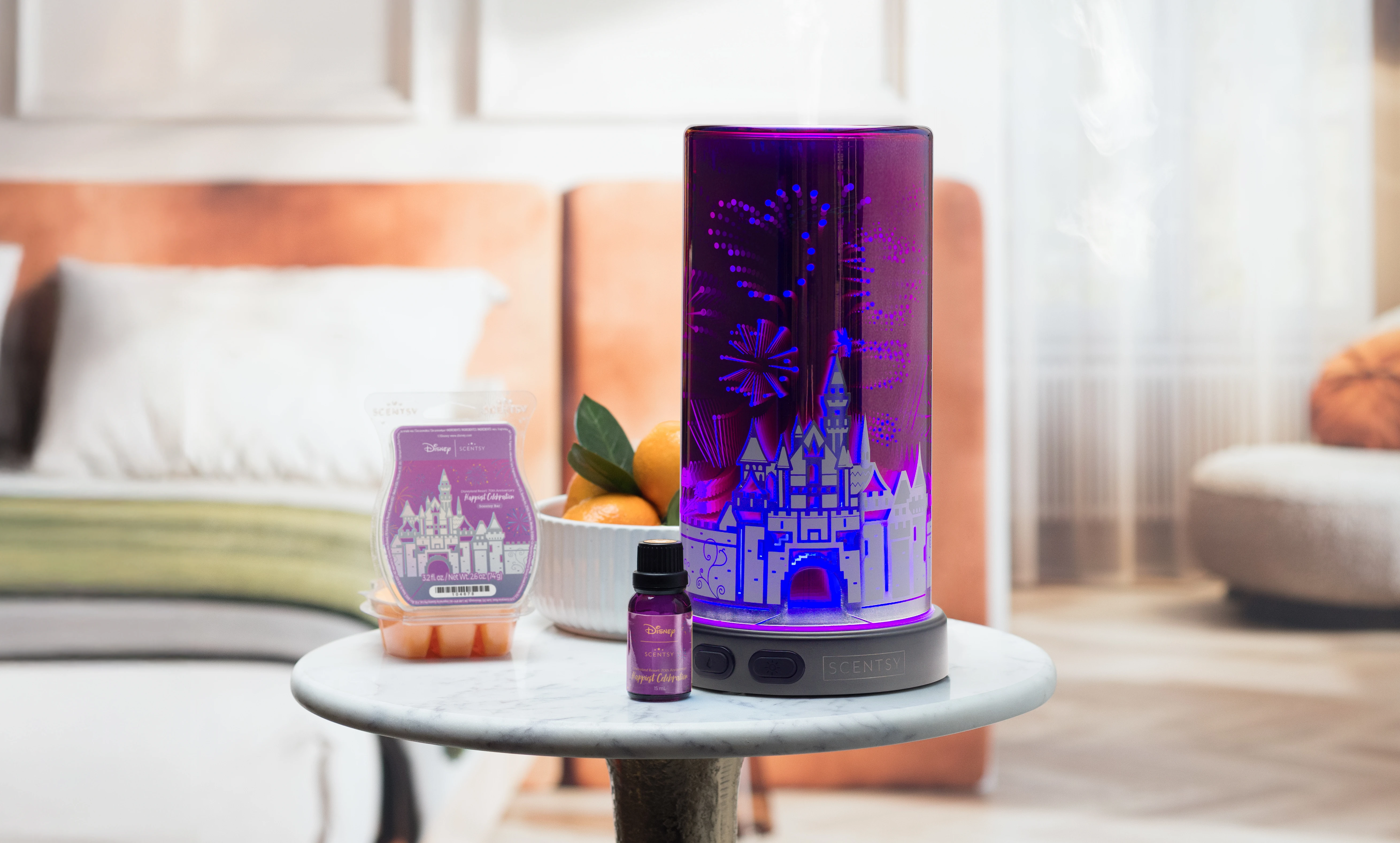 Disneyland Resort 70th Anniversary Celebration: Sleeping Beauty Castle Scentsy Diffuser glowing purple and blue on a side table, releasing mist, alongside the Happiest Celebration Natural Oil and Scentsy Bar in a bright, modern bedroom.