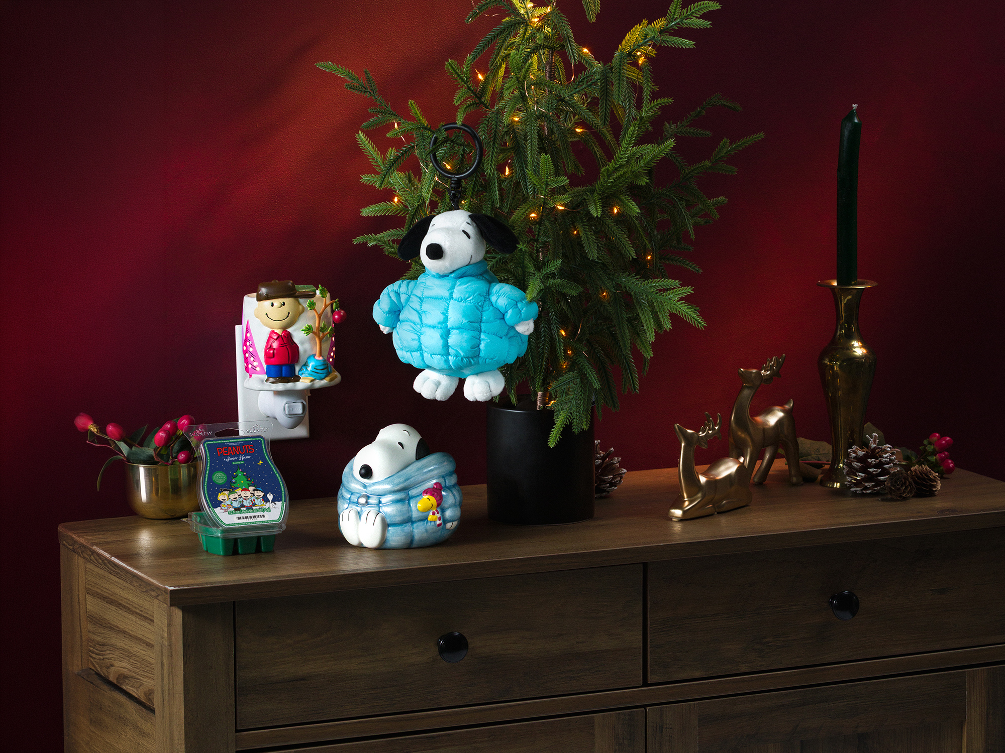 Peanuts™ Holiday products are displayed around a small tree and decorations.