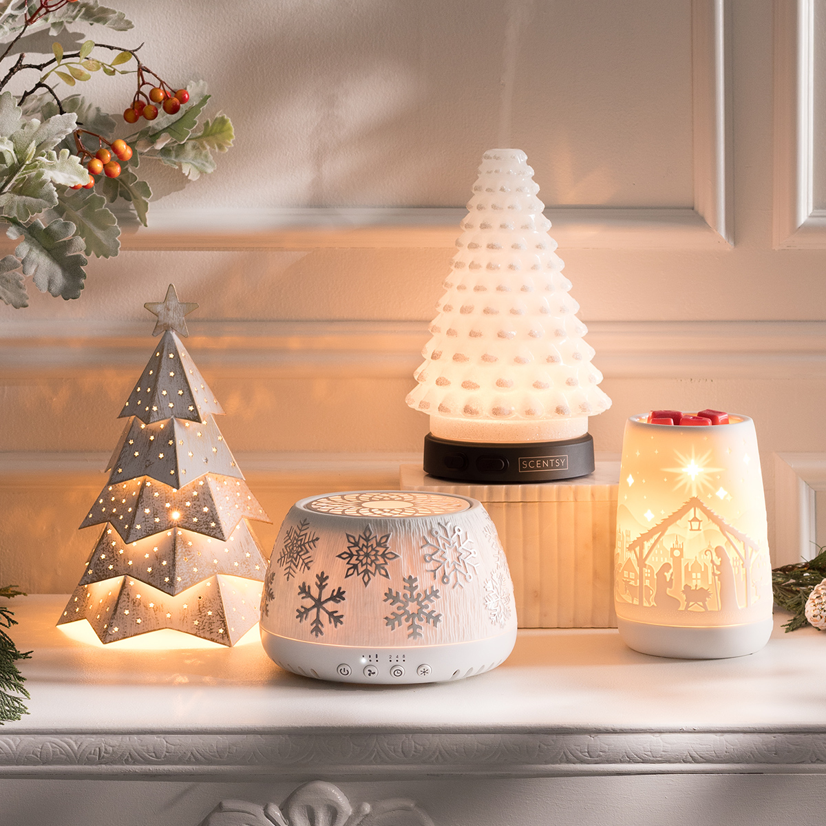 Festive holiday display featuring two Scentsy Warmers, the Scentsy Air Quad – Silver Snowflake, and a Diffuser from the Holiday Collection, softly glowing to create a warm and inviting seasonal ambiance.