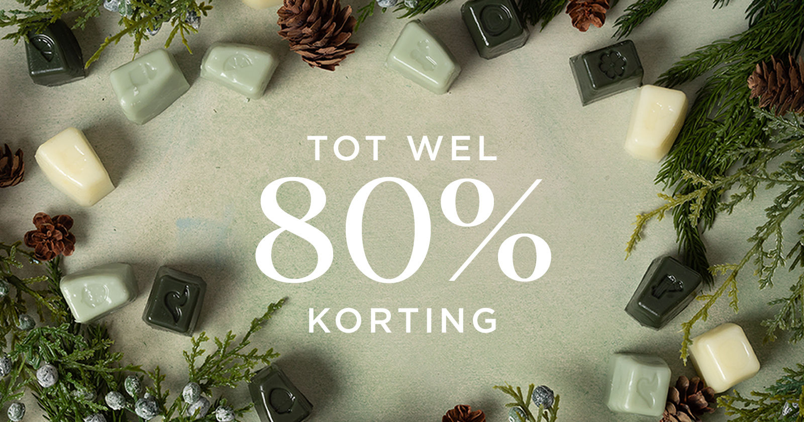 Feestelijke flatlay met verschillende Scentsy-wasblokjes in een cirkelvormig patroon met dennenappels en groenblijvende takken, rond de witte tekst “Bespaar tot 80%” op een zachtgroene achtergrond.