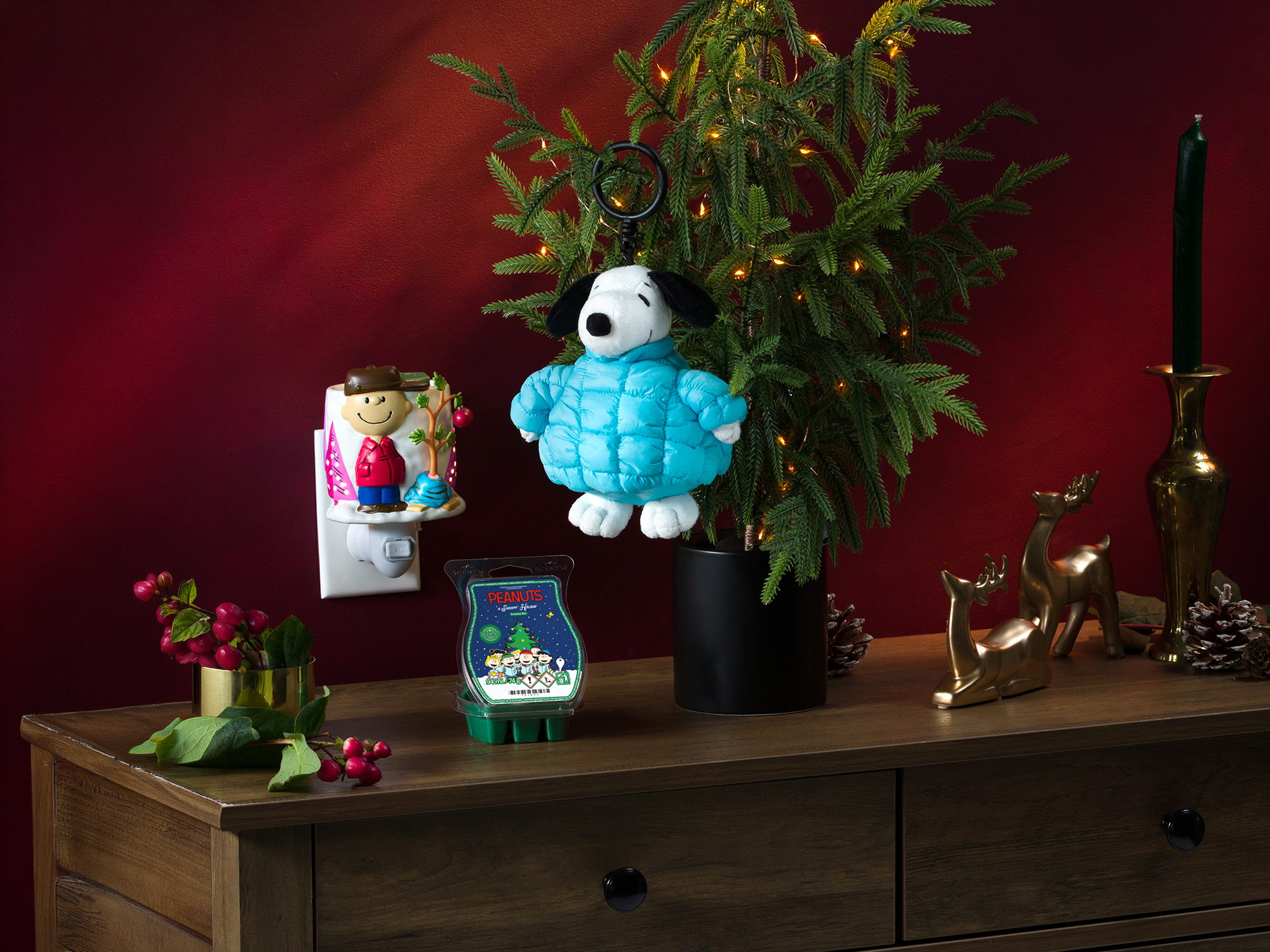 Die Peanuts™-Produkte für die Feiertage sind rund um einen kleinen Baum und Weihnachtsschmuck ausgestellt.