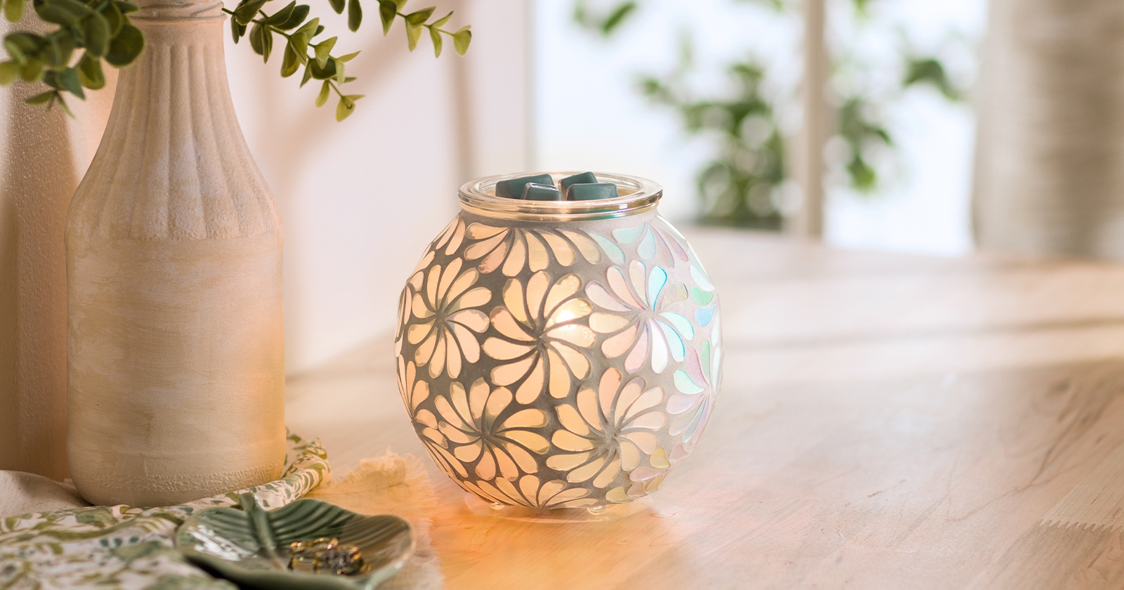 Scentsy Amanita glass irridescent mushroom warmer on a side table next to a peach