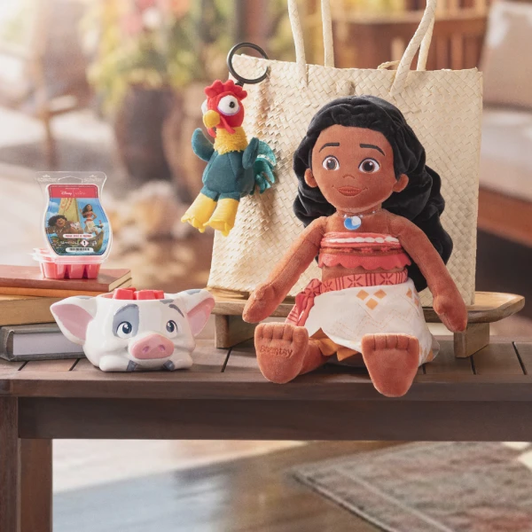 Disney Moana (Vaiana) Collection products are displayed on a table with a large straw bag. 