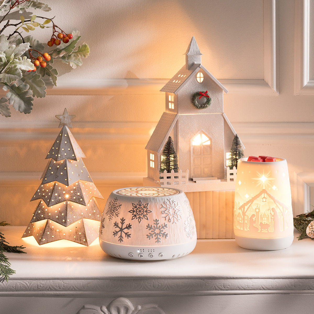 A cozy holiday mantel display featuring several Scentsy Warmers and the Scentsy Air Quad – Silver Snowflake from the Holiday Collection, softly glowing with warm light to create a festive, inviting ambiance.