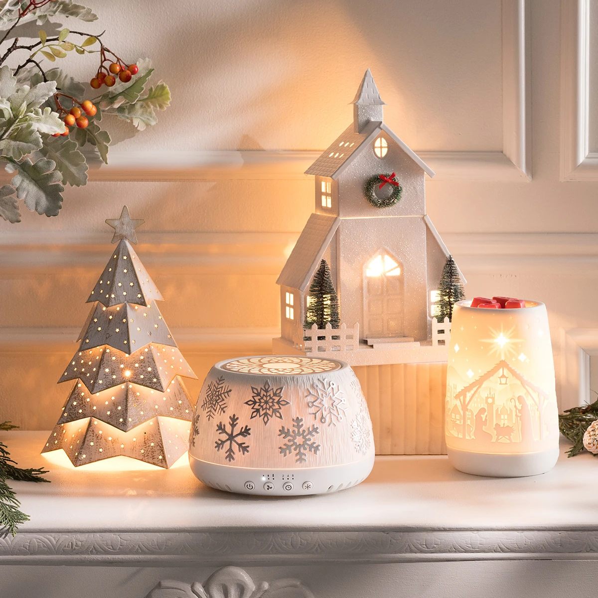 A cozy holiday mantel display featuring several Scentsy Warmers and the Scentsy Air Quad – Silver Snowflake from the Holiday Collection, softly glowing with warm light to create a festive, inviting ambiance.