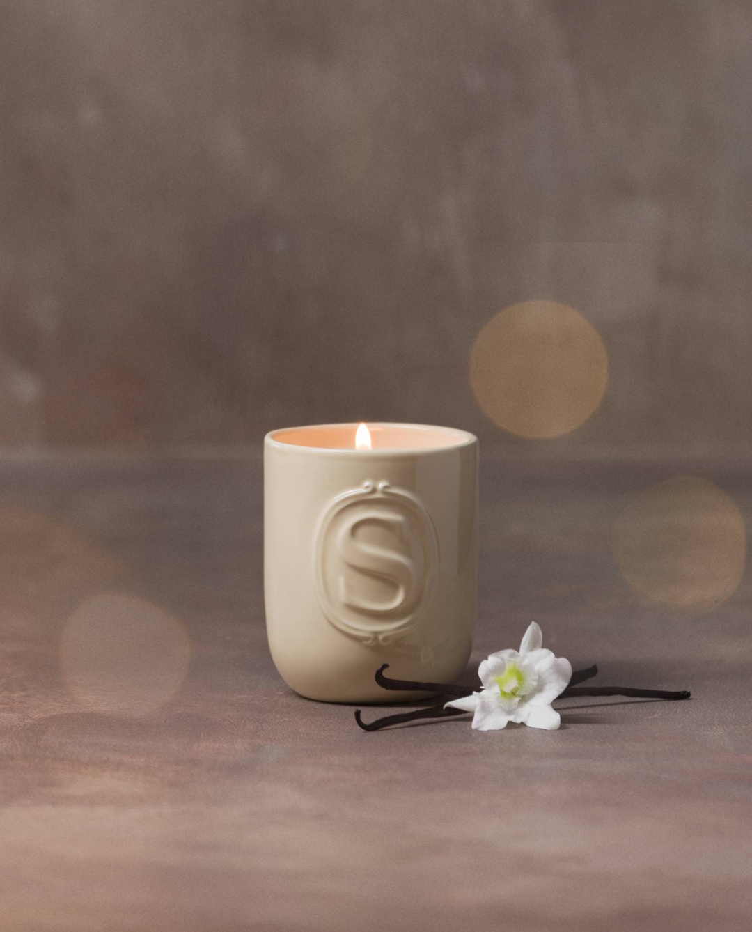 Scentsy Eucalyptus Wreath Candle in a glass jar, surrounded by lush green botanicals, set against a green background.