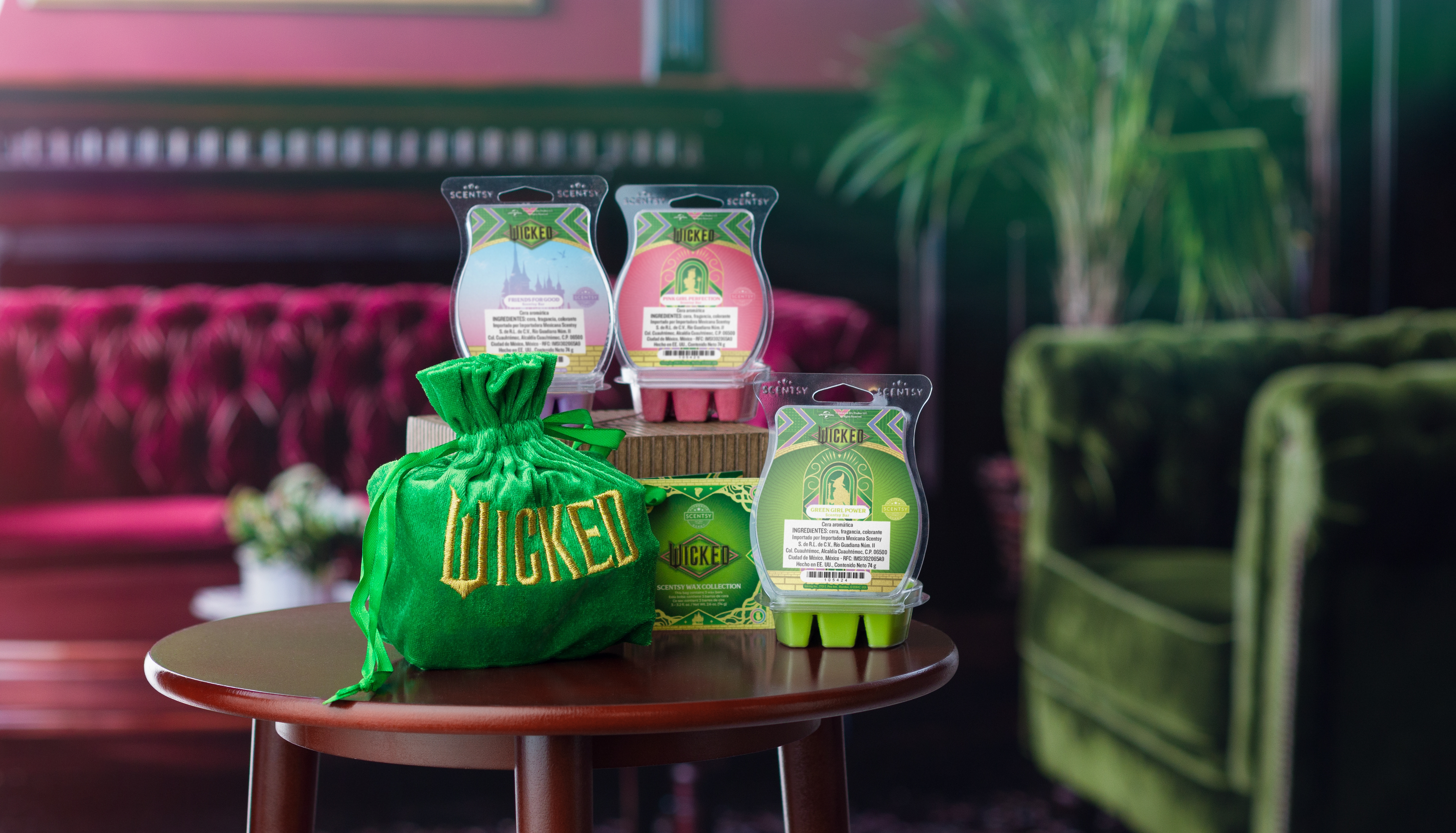 Los productos de la Colección Wicked arreglados en una pequeña mesa de madera en un ambiente con estilo art déco con detalles rosados y verdes.