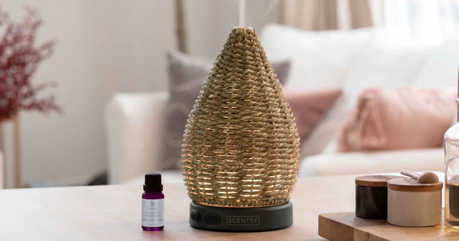 Wonder Diffuser in hand-woven natural jute with a black base, styled on a tabletop in a soft, spa-inspired home setting.