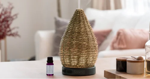 Wonder Diffuser in hand-woven natural jute with a black base, styled on a tabletop in a soft, spa-inspired home setting.