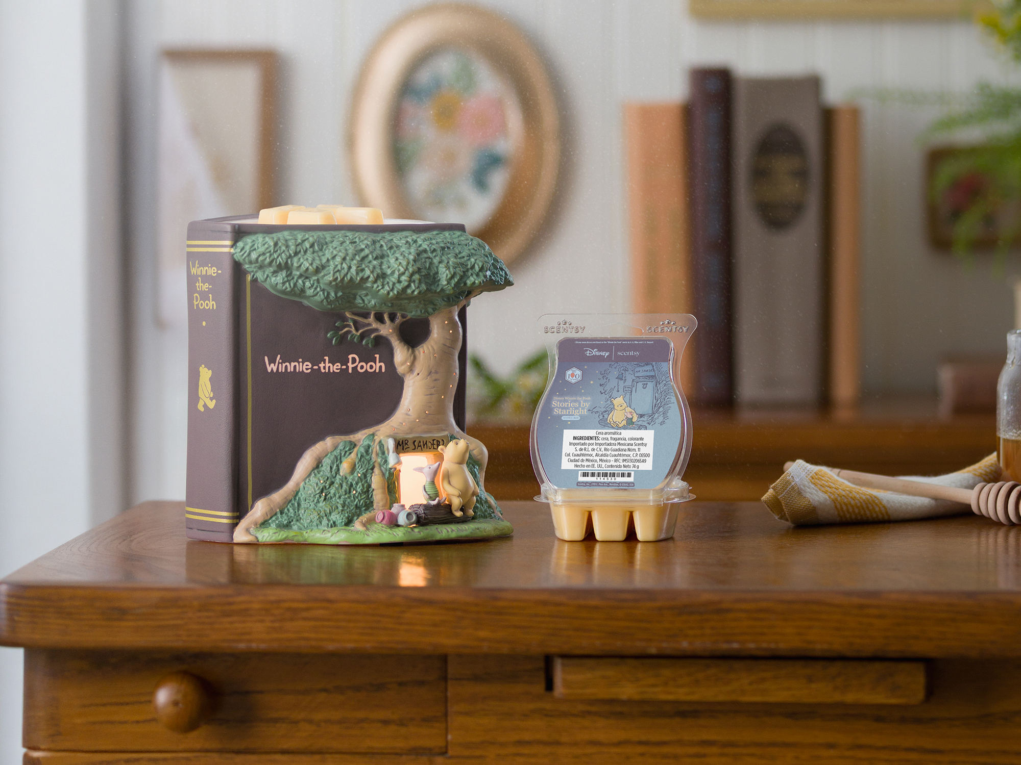 Un Calentador Scentsy – Disney Winnie the Pooh: 100 Years of Friendship se muestra junto a una Barra Scentsy – Disney Winnie the Pooh: Stories by Starlight abierta.