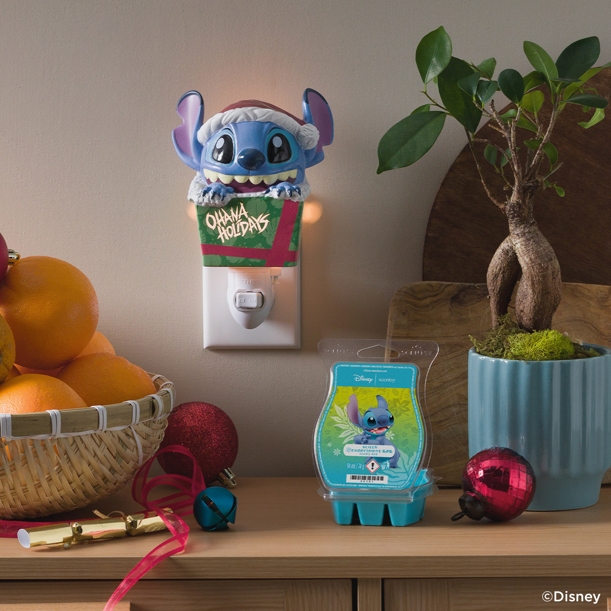 Elektrische Duftlampe und Düfte aus der Disney Lilo & Stitch Feiertagskollektion von Scentsy, für die Startseite in Szene gesetzt.