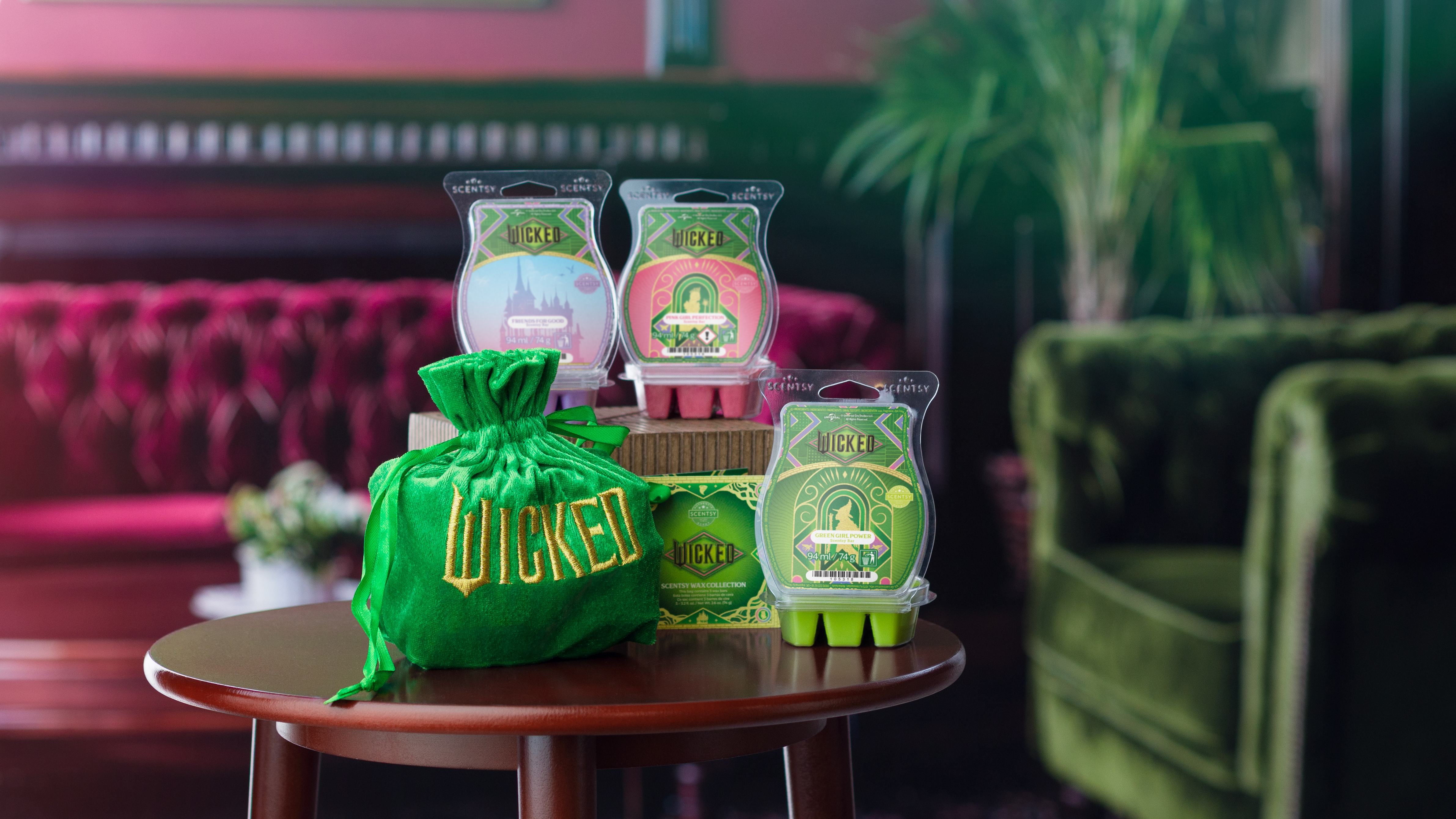 Wicked Collection products arranged on a small wood table in an art deco setting with pink and green accents.