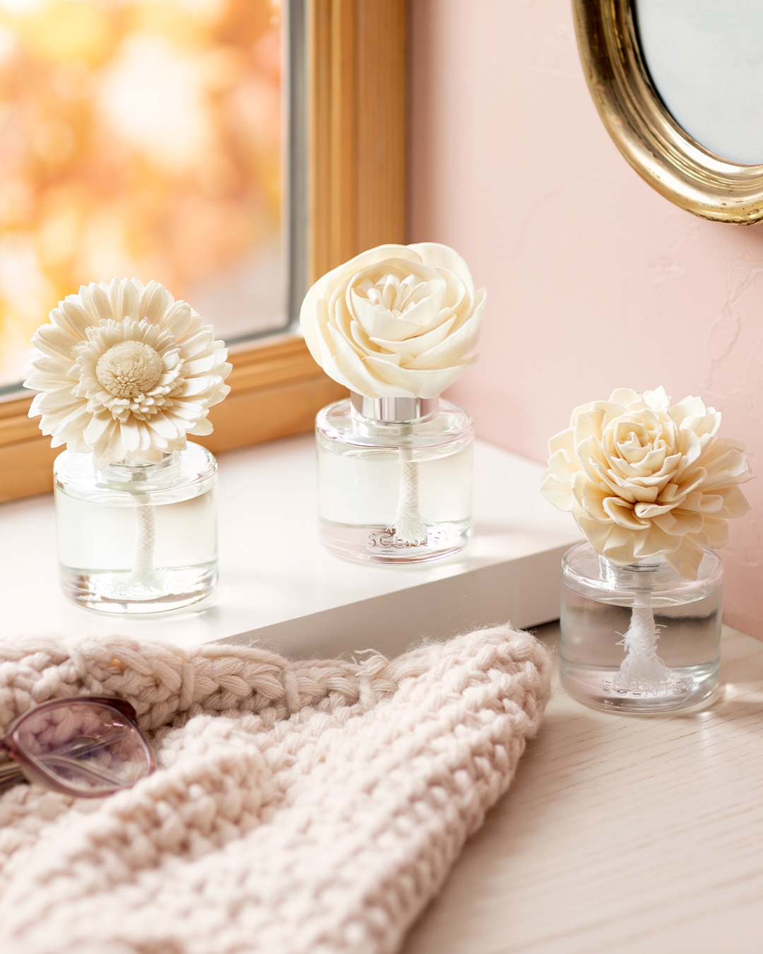 Scentsy Firewood Spruce Candle in a glass jar, surrounded by snowflakes, pine needles, and wood shavings on a blue background.
