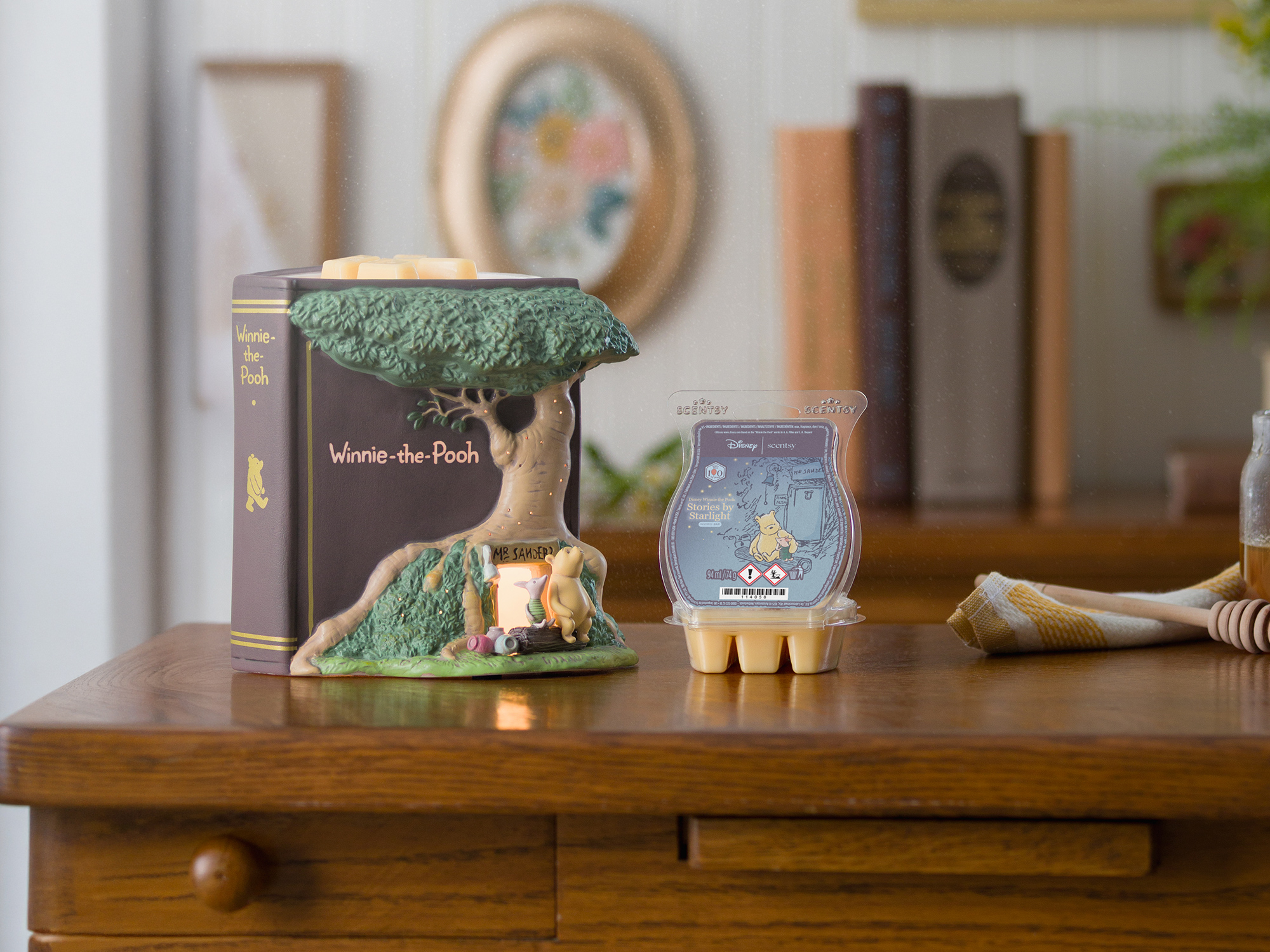 Eine Elektrische Duftlampe – Disney Winnie the Pooh: 100 Years of Friendship ist neben einem offenen Scentsy Bar – Disney Winnie the Pooh: Stories by Starlight ausgestellt.
