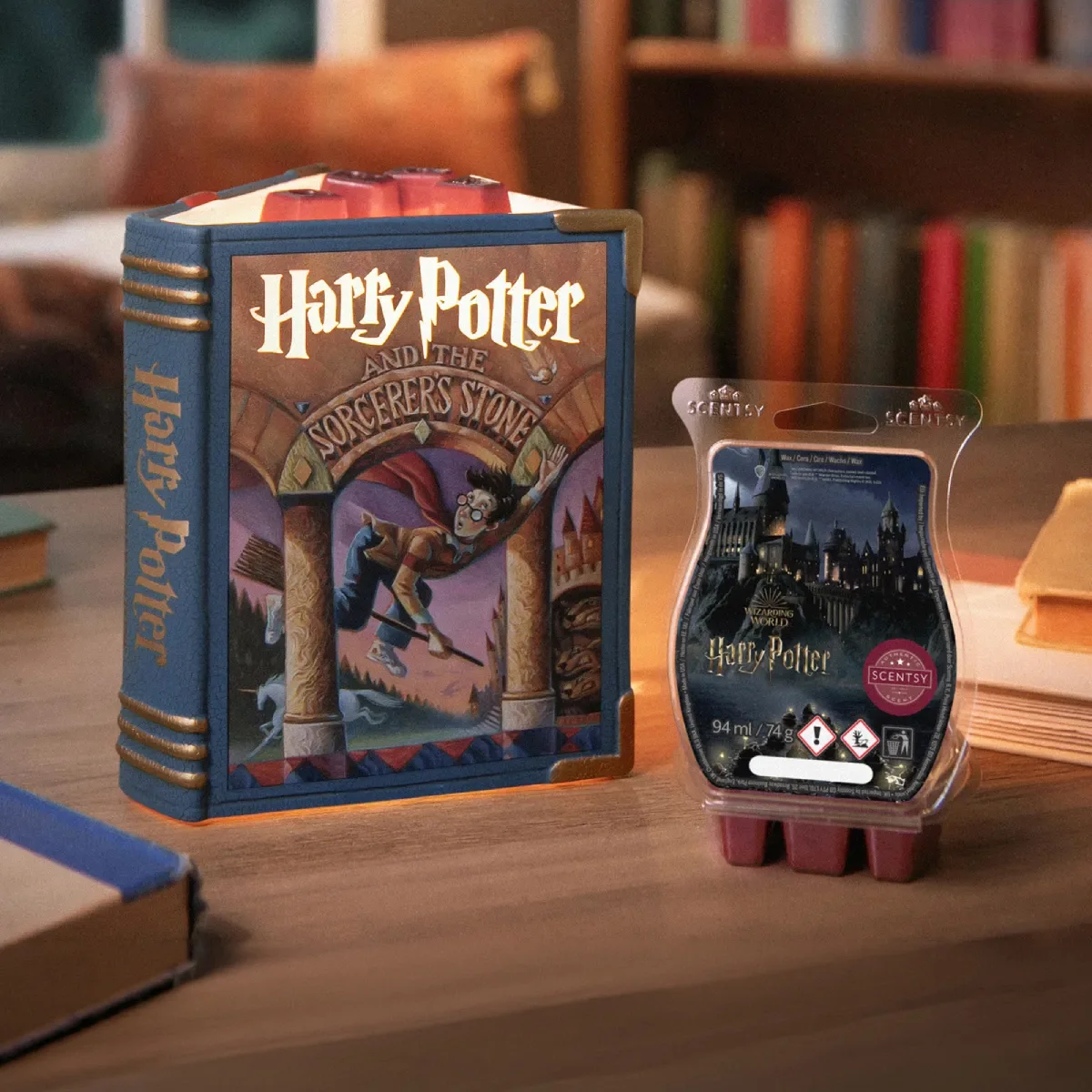 Die Elektrische Duftlampe – Harry Potter and the Sorcerer’s Stone und der Scentsy Bar – Wizarding World: Harry Potter sind auf einem Couchtisch zwischen einem Stapel Bücher in einer Leseecke ausgestellt.