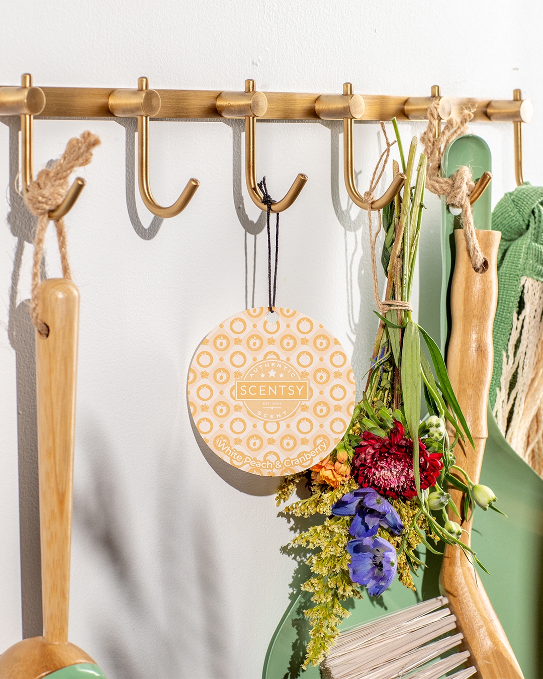 Scentsy Sugared Peppermint Pine Candle in a glass jar, surrounded by green pine needles and red and white peppermint candies on a vibrant red background.