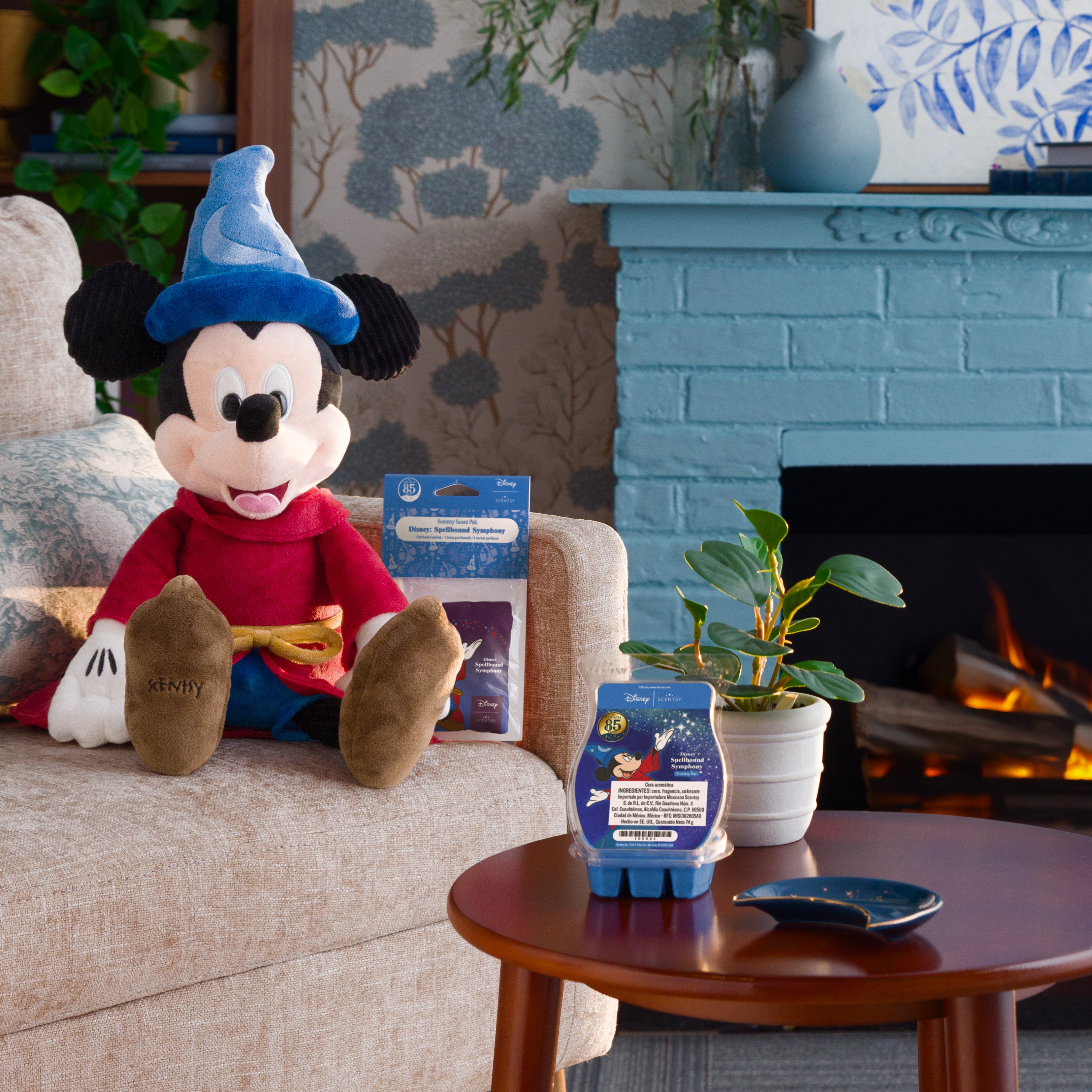 Los productos de la Colección Disney Fantasia incluido el Ratón Mickey como aprendiz de brujo se muestran en una mesa y un sofá en un entorno de sala.