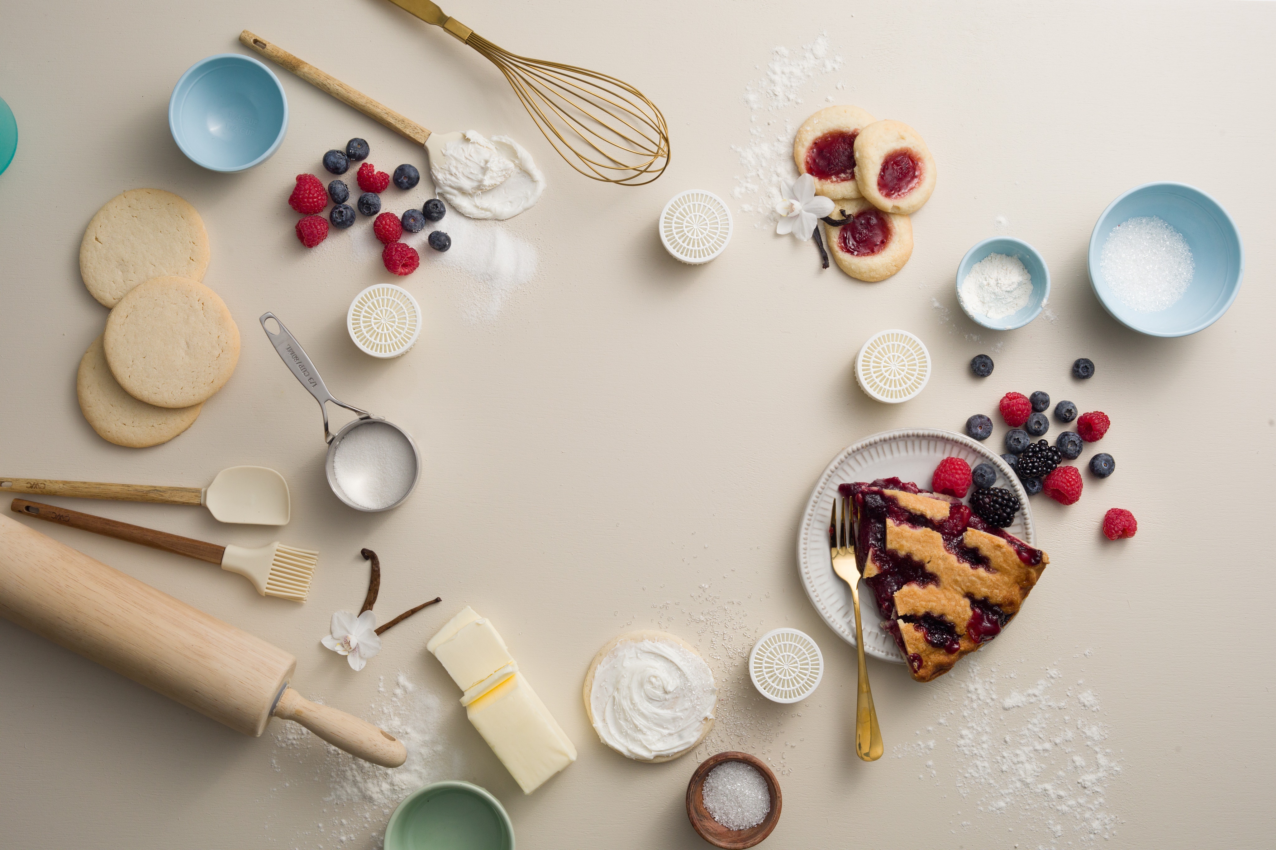 Various baking items measuring cups, whisks, pastries, berries and Scentsy pods