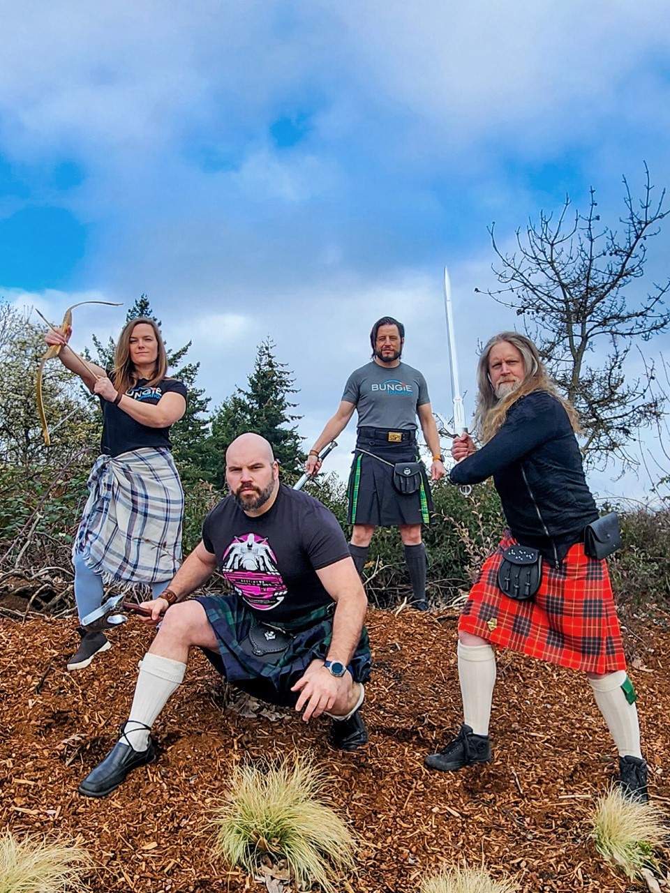 Pictured: A woman on the left and three men to the right of her wearing kitls and weilding fantasy swords to represent the charity initiative being spoken about.