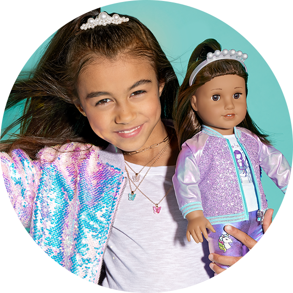 Girl in matching sequin outfit with doll
