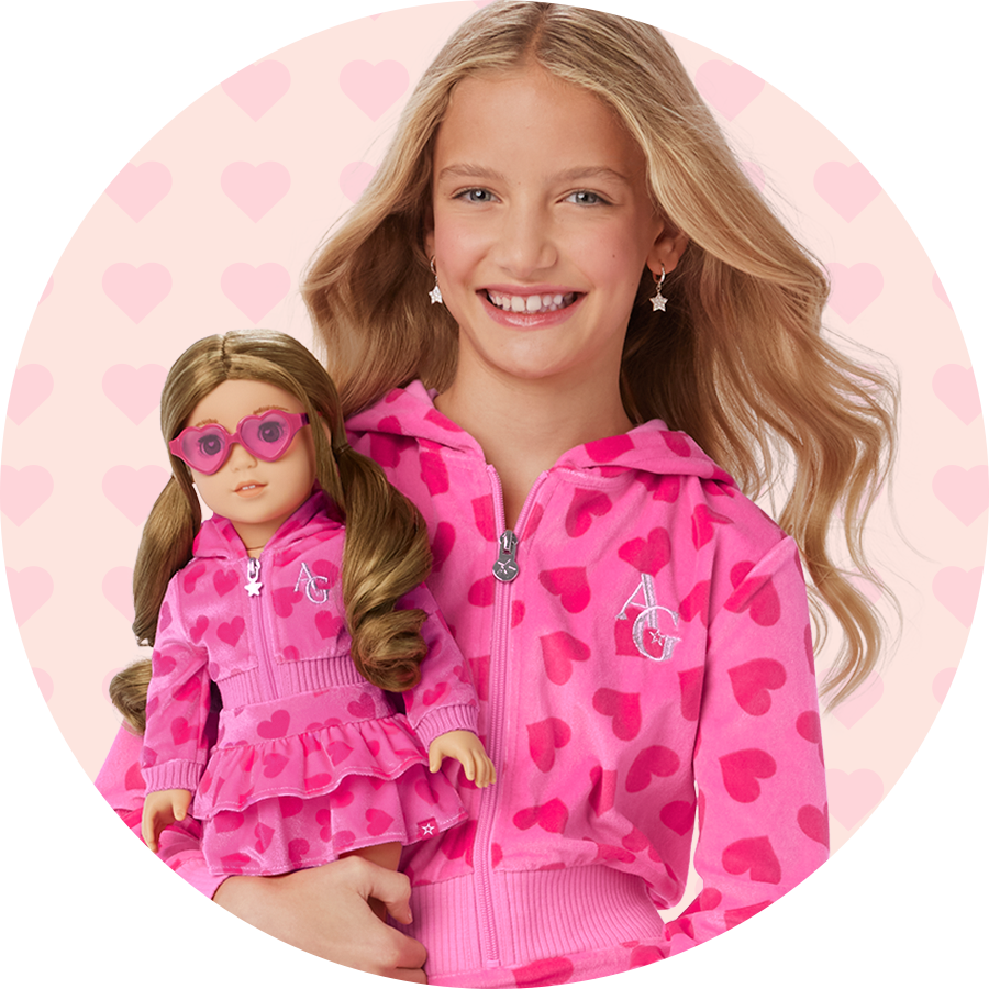 Young girl and doll in a matching pink set