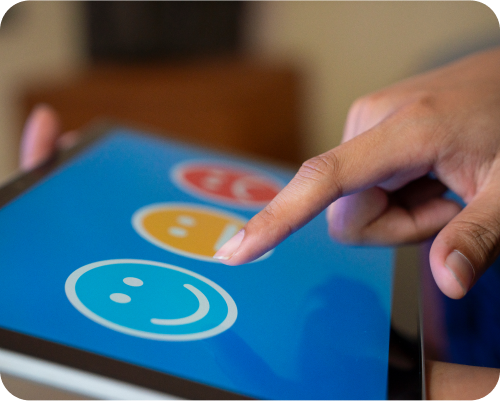 A tablet phone with a blue background showing different color smileys to ensure color-related challenges