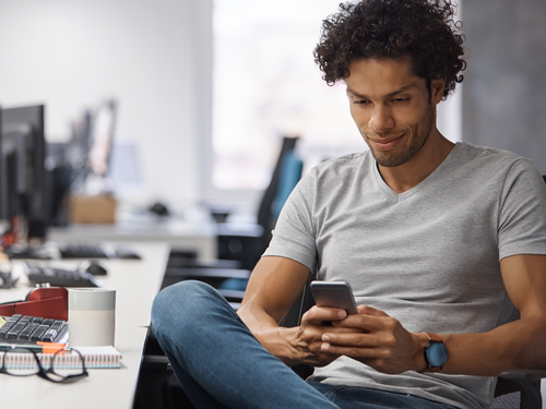 Man in gray shirt experiencing personal customer experience care of APIs on his mobile phone