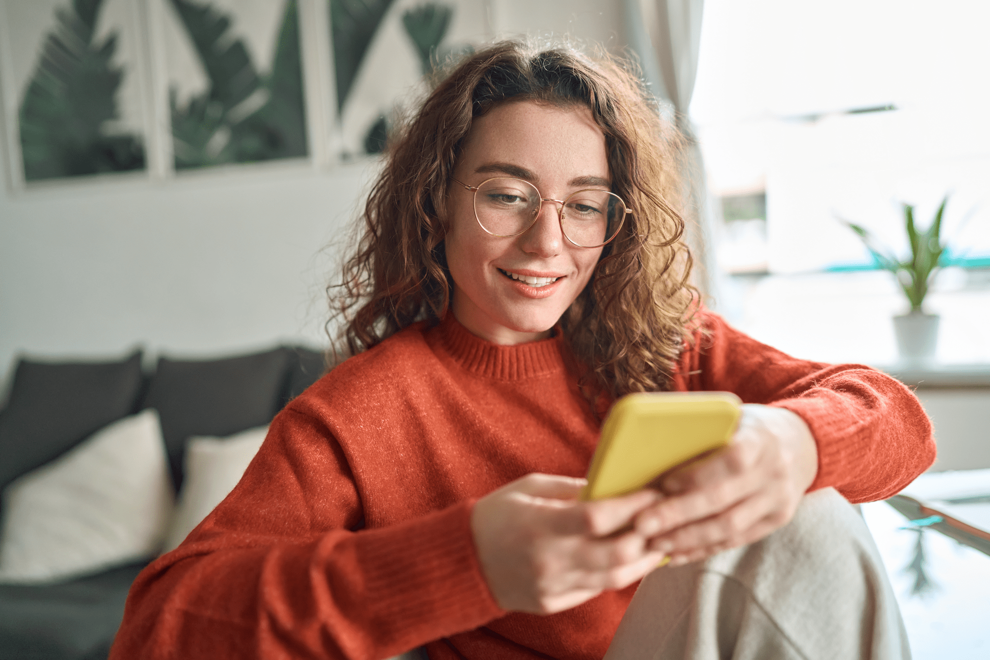 stock-photo-young-smiling-woman-wearing-glasses-holding-smartphone-using-cellphone-modern-technology-looking ransformed