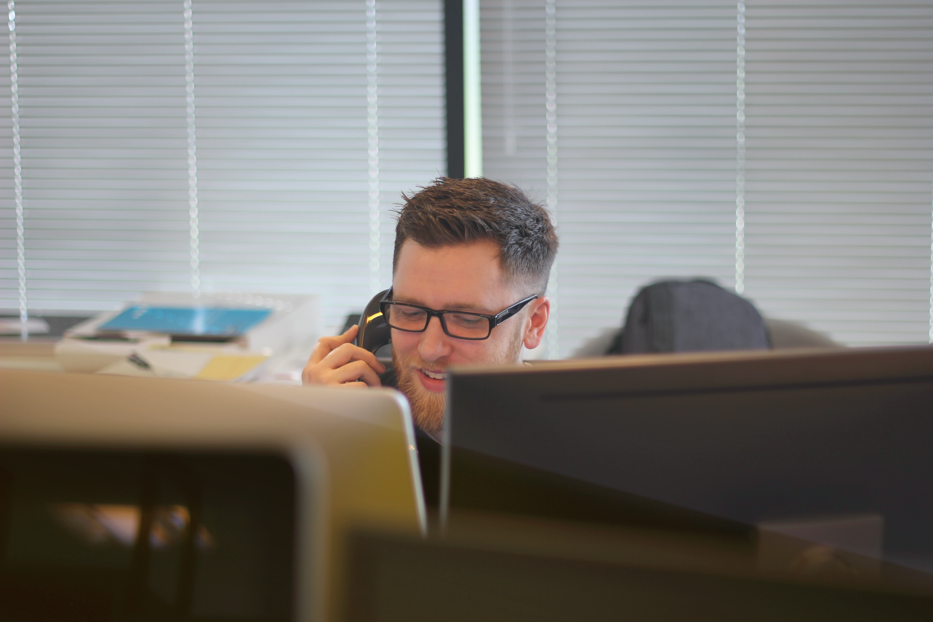 man-in-office-using-fixed-voip-on-desk-phone.png