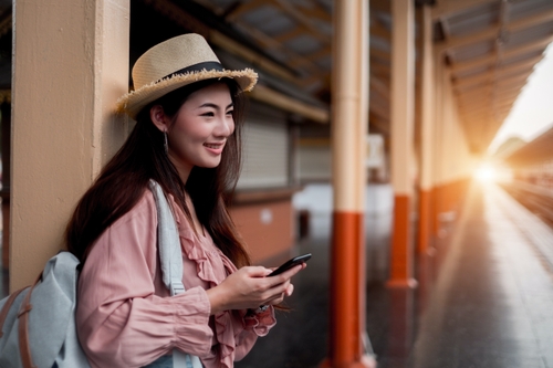 หญิงสาวที่สถานีรถไฟได้รับ SMS แจ้งเตือนเกี่ยวกับธุรกรรมของเธอ