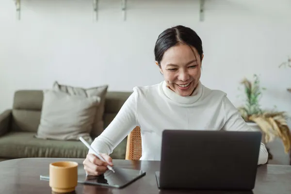 Wanita tersenyum saat panggilan video di komputernya