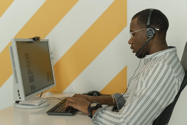 A call center manager supervising a customer phone call