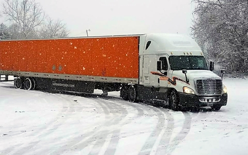 A Schneider driver turns cautiously on snowy roads.