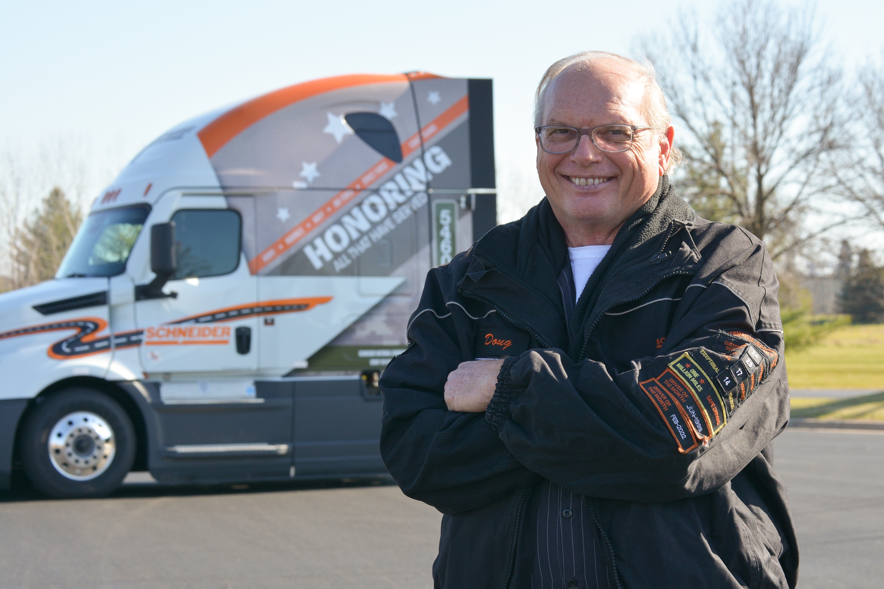 Doug Huber standing in front of the military-wrapped truck he will be driving.