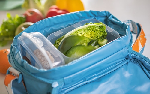 A small blue cooler containing produce. 