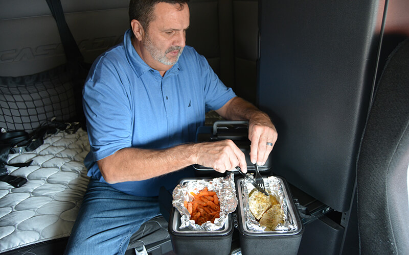 Truck driver cooking in a semi truck